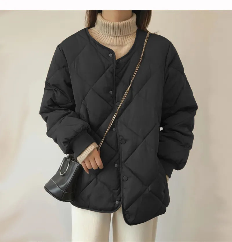 Schwarze gesteppte Damenjacke mit Knopfleiste, kombiniert mit beigem Rollkragenpullover und kleiner schwarzer Umhängetasche. Wintermode-Trend.