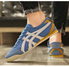 Blaue Sneaker mit weißem Streifenmuster, gelber Ferse und Gummisohle. Ideal für Sport und Freizeit. Bequeme, modische Turnschuhe für Damen.