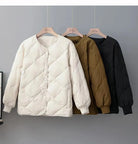 Drei gesteppte Jacken in Weiß, Braun und Schwarz auf Kleiderbügeln. Modische Damenjacken, ideal für Herbst und Winter. Hochwertige Materialien.