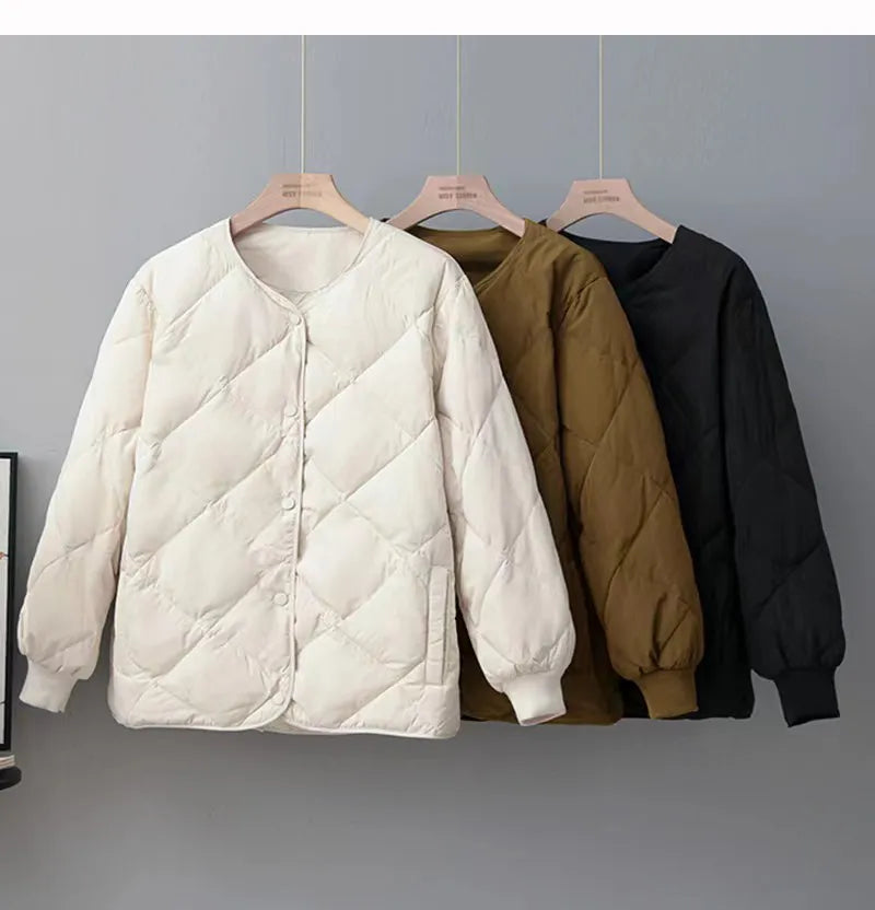 Drei gesteppte Jacken in Weiß, Braun und Schwarz auf Kleiderbügeln. Modische Damenjacken, ideal für Herbst und Winter. Hochwertige Materialien.