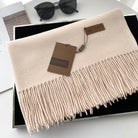Eleganter beiger Schal mit Fransen von GERUNSI, ideal für Herbst und Winter. Hochwertige Modeaccessoires, stilvoll und vielseitig kombinierbar.
