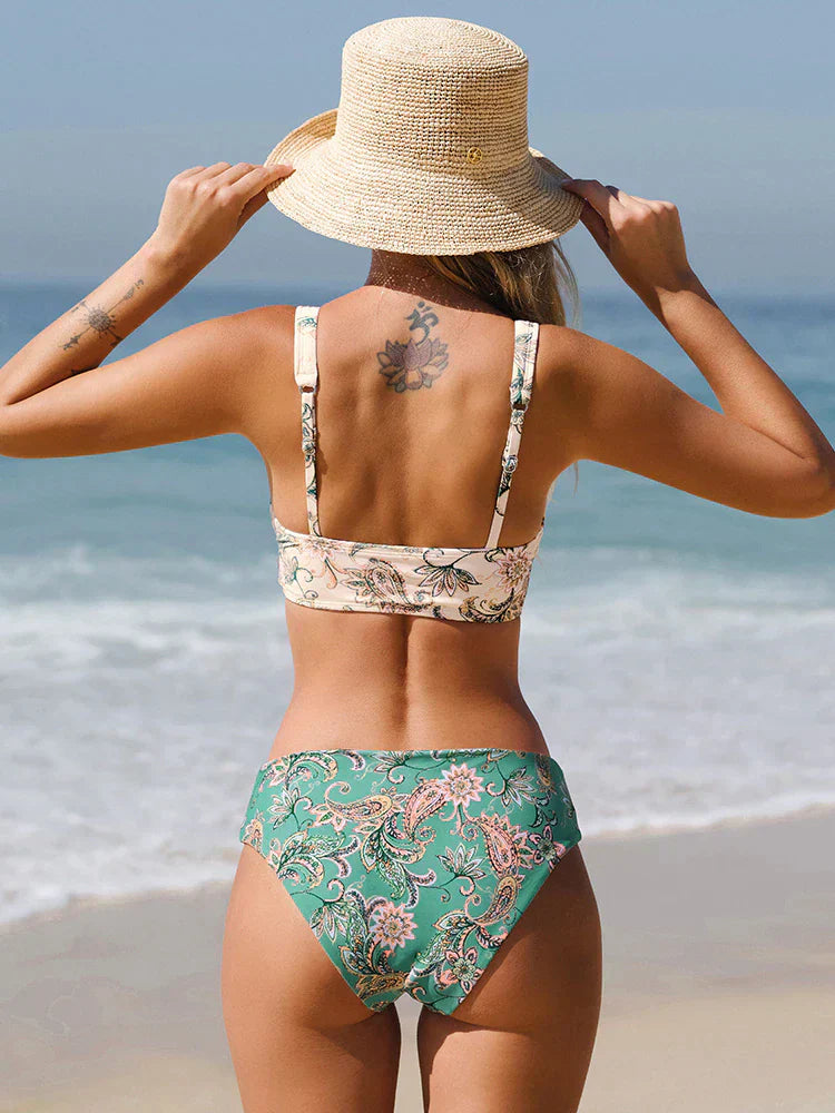 Frau am Strand in grünem, geblümtem Bikini und Strohhut. Sommermode, Strandbekleidung, Bademode, Urlaub, Meer, stilvoll, trendy.
