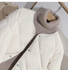 Weiße Steppjacke über grauem Rollkragenpullover, stilvoll und warm. Perfekt für Herbstmode, Damenbekleidung, Winteroutfits, Layering.