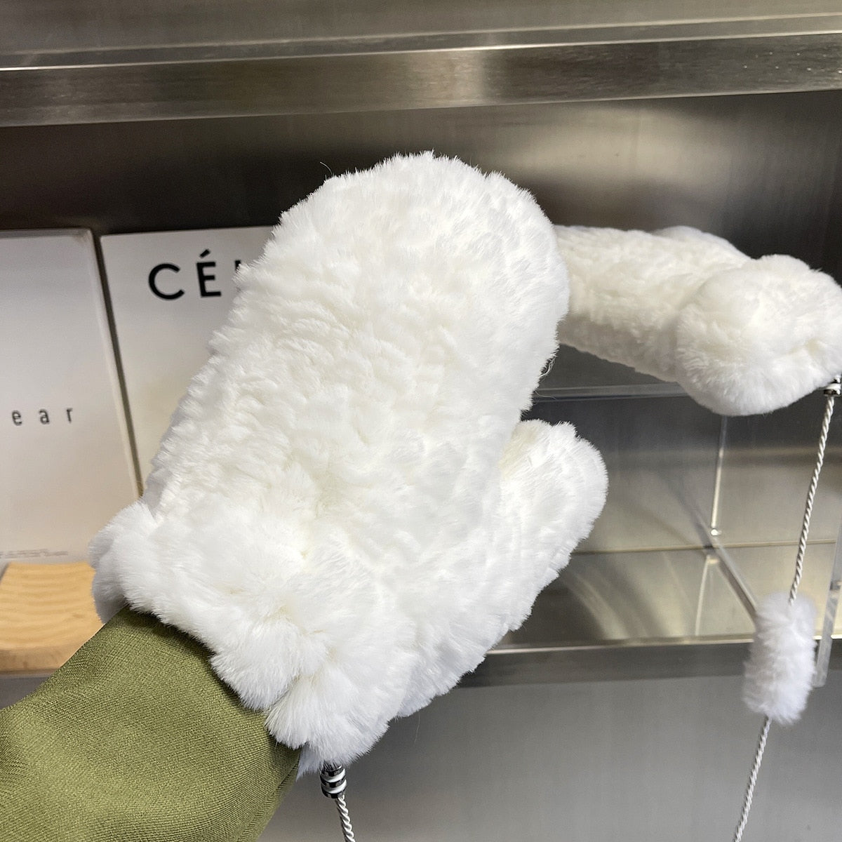 Weiße, flauschige Fäustlinge aus Kunstfell, ideal für kalte Wintertage. Modisches Accessoire für Damen, warm und stilvoll. Wintermode 2023.