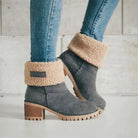 Graue Damenstiefeletten mit Blockabsatz und Kunstfellfutter, kombiniert mit blauen Jeans. Modische Winterstiefel, bequem und stilvoll.