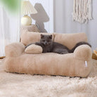 Graues Kätzchen auf beigem Plüschsofa, gemütliches Katzenbett, Wohnzimmerdekoration.