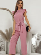 Femininer Jumpsuit in Rosa mit Rüschenärmeln und Taillengürtel, ideal für elegante Anlässe. Perfekt für stilvolle Damenmode.