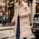 Eleganter, beiger Daunenmantel für Damen, ideal für Wintermode. Perfekt für stilvolle, warme Outfits in der kalten Jahreszeit.