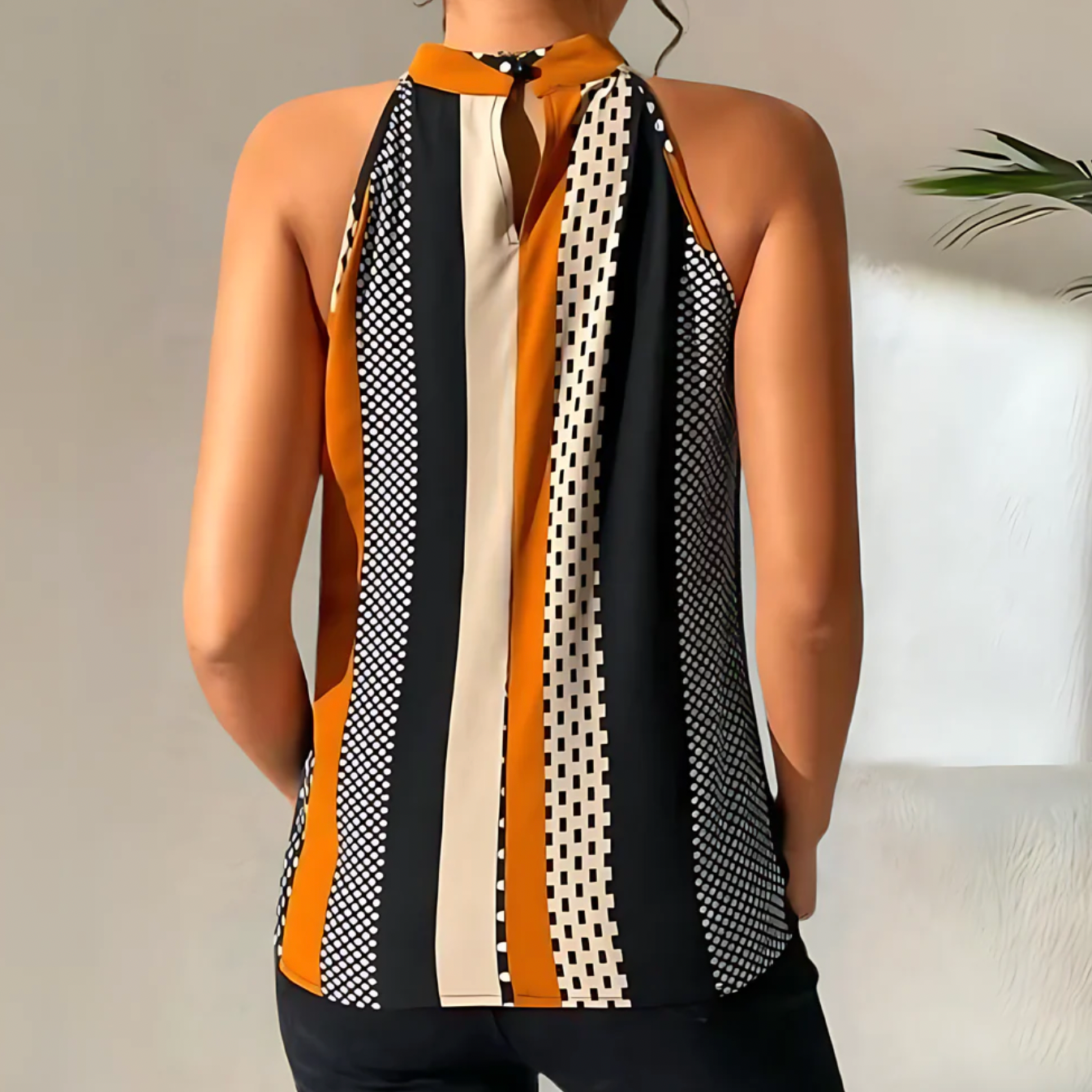 Ärmellose Damenbluse mit geometrischem Muster, vertikalen Streifen in Schwarz, Weiß und Orange. Modische Sommerbekleidung, elegant und stilvoll.