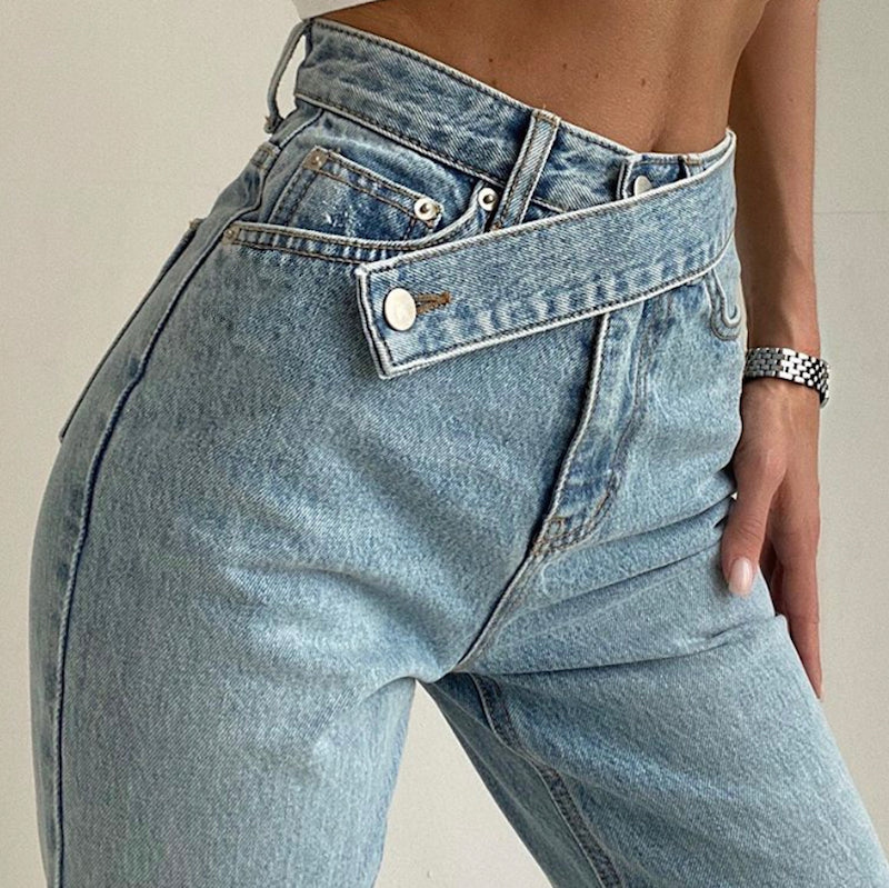 Damen-High-Waist-Jeans in hellblauer Waschung, modisch mit asymmetrischem Knopfverschluss. Perfekt für trendige Streetwear-Looks.