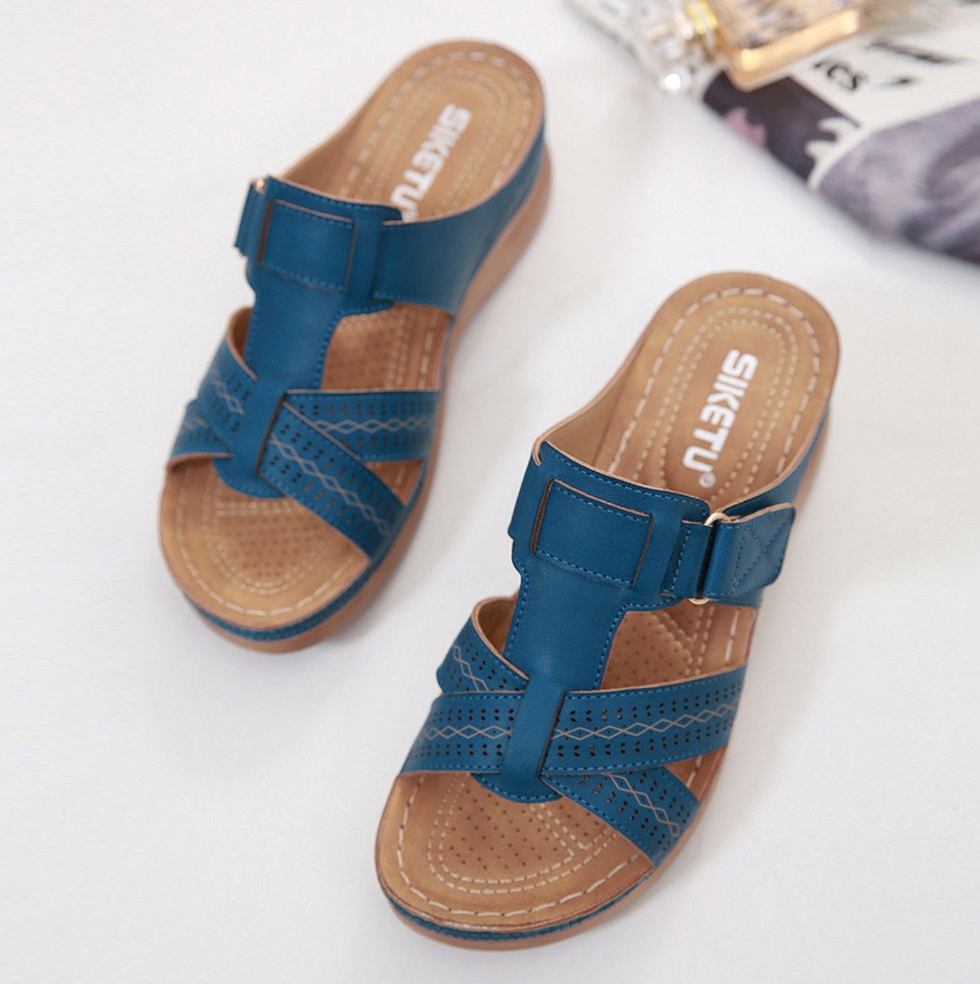 Blaue Damen-Sandalen mit Keilabsatz, verstellbarem Riemen und perforiertem Design. Bequem, modisch, ideal für Sommer und Freizeit.