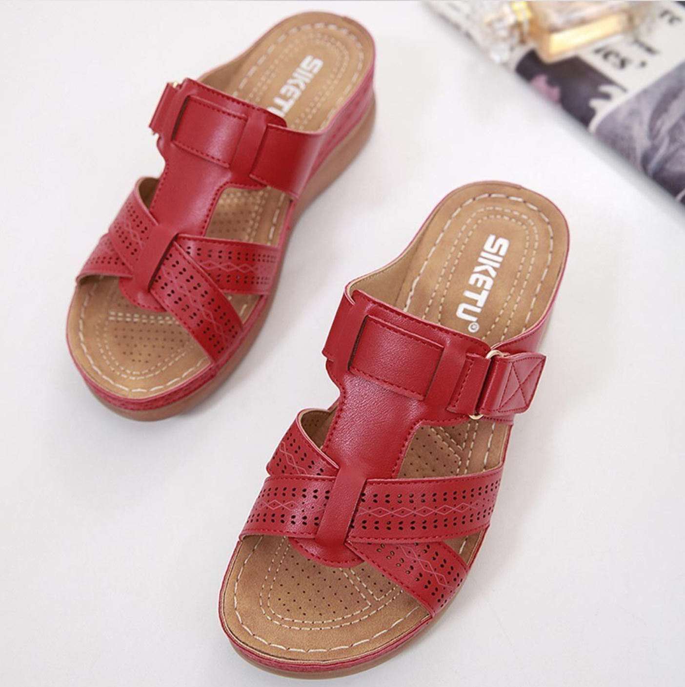 Rote Damen-Sandalen mit Keilabsatz, perforiertem Design und verstellbarem Riemen. Bequeme Sommerschuhe für stilvolle Freizeitoutfits.