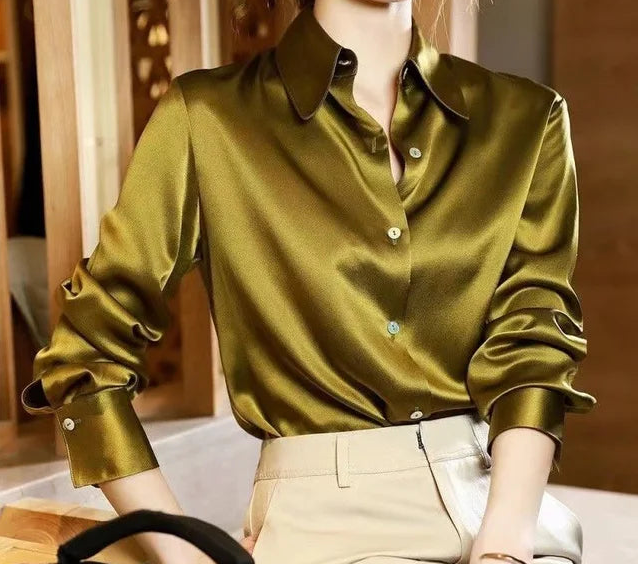 Elegante Damenbluse aus glänzendem Satin in Olivgrün, kombiniert mit beigen Hosen. Perfekt für stilvolle Business- und Freizeitlooks.