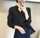 Elegante schwarze Bluse für Damen, kombiniert mit passender Hose. Perfekt für Büro-Outfits und modische Alltagslooks. Hochwertige Damenmode.