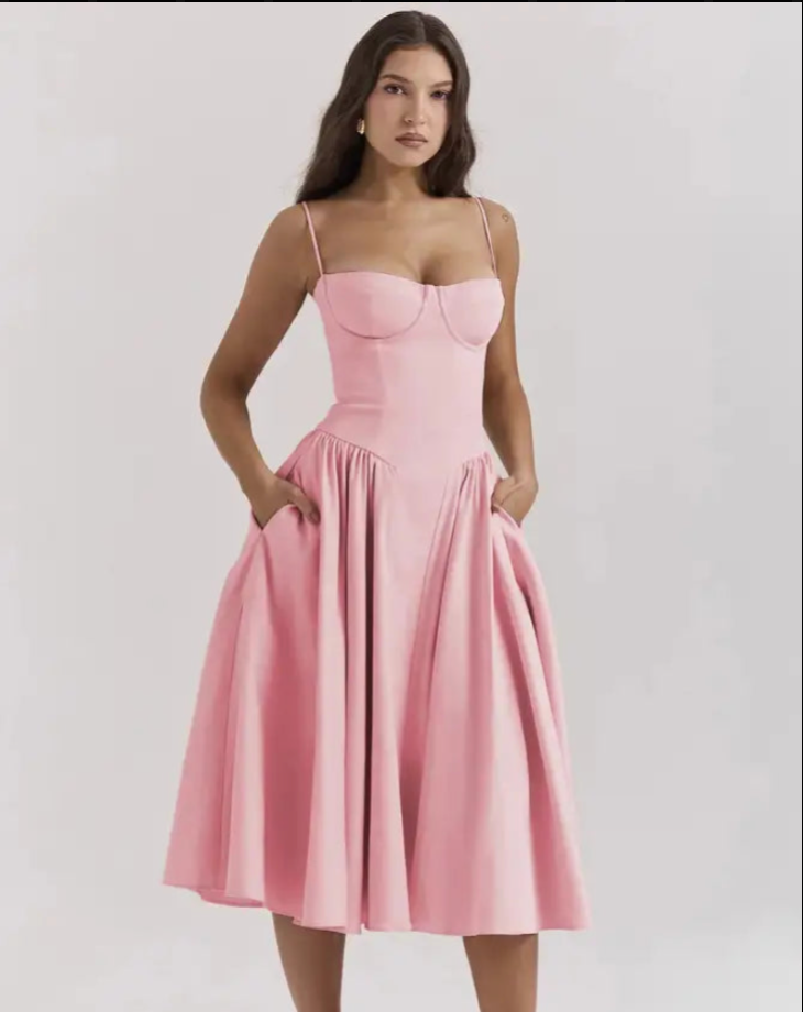 Frau in rosa Cocktailkleid mit Spaghettiträgern, ausgestelltem Rock, elegantes Abendmode-Outfit.