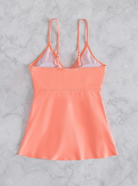 Pfirsichfarbenes Damen-Top mit verstellbaren Trägern auf Marmorhintergrund. Sommermode, elegantes Design, atmungsaktiver Stoff.