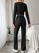 Damen-Loungewear-Set in Schwarz, langärmeliges Oberteil und weite Hose, bequem und stilvoll, ideal für Freizeit und Entspannung zu Hause.