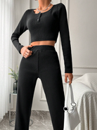 Elegantes schwarzes Damen-Zweiteiler-Set mit langärmligem Crop-Top und Hose. Perfekt für stilvolle Freizeit- und Abendmode.