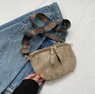 Beige Umhängetasche mit verstellbarem, gemustertem Riemen auf Jeansstoff. Modisch, vielseitig, ideal für Alltag und Reisen.