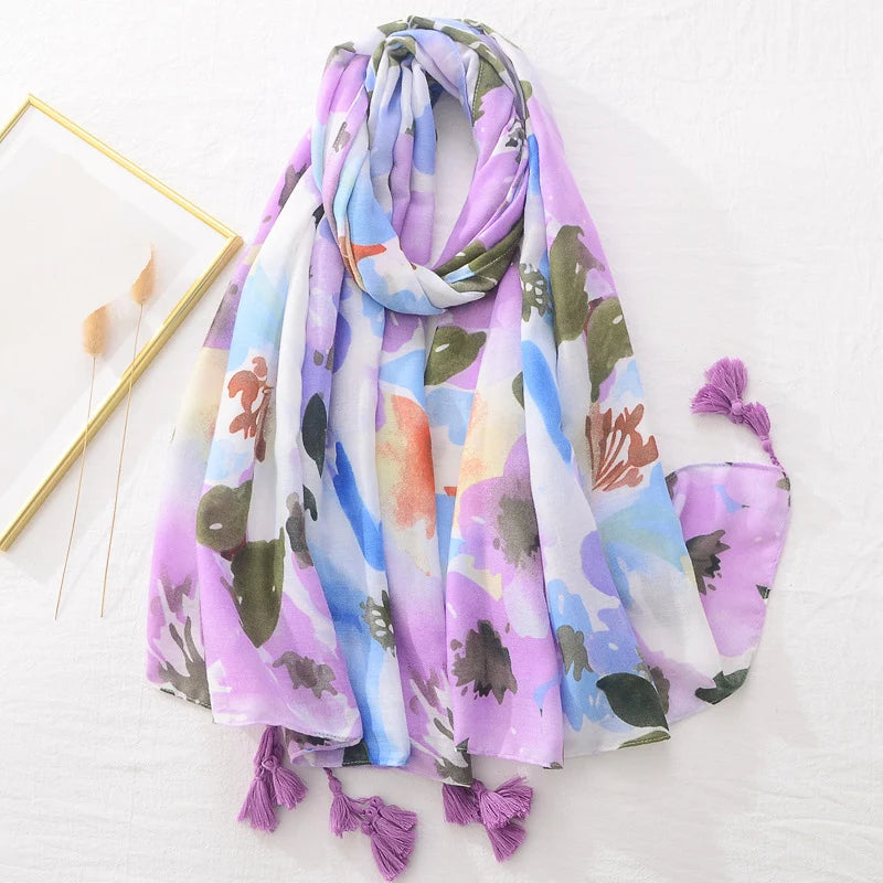 Bunter Schal mit floralem Muster, lila und blauen Akzenten, weichem Stoff und Quasten. Perfekt für Frühling und Sommermode.