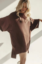 Frau in braunem Oversize-T-Shirt, lässige Mode, bequeme Damenbekleidung, Tageslicht.