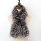 Eleganter Kunstpelzschal in Grau auf Schneiderpuppe. Flauschiges Accessoire für Wintermode, ideal für stilvolle Outfits und kalte Tage.