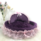 Lila Hundebett mit rosa Rüschen, Plüschmaterial, dekorativer Schleife, luxuriöses Haustierbett.