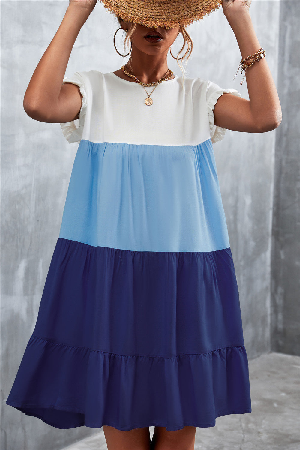 Feminines Sommerkleid in Blau-Weiß, ärmellos, mit Rüschen und Stufenrock. Perfekt für Strandmode und Freizeitoutfits.