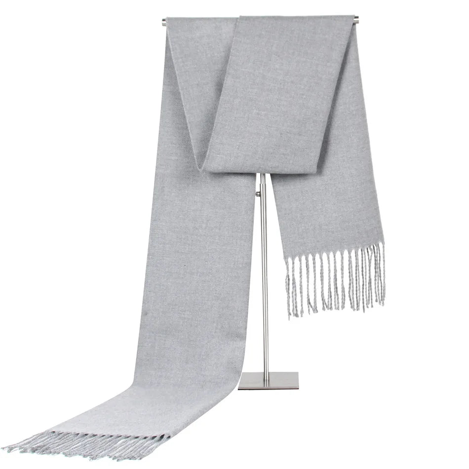 Grauer Kaschmirschal mit Fransen, luxuriös und weich, ideal für kalte Wintertage. Hochwertige Modeaccessoires, stilvoll und zeitlos.