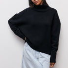 Schwarzer Rollkragenpullover aus weichem Strick, kombiniert mit einem hellen Jeansrock. Modischer Look für Herbst und Winter.