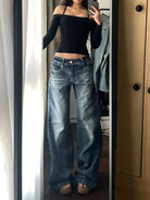 Frau in weitem Jeans und schwarzem Off-Shoulder-Top, Spiegel-Selfie. Trendige Damenmode, lässiger Streetstyle, modische Outfits.