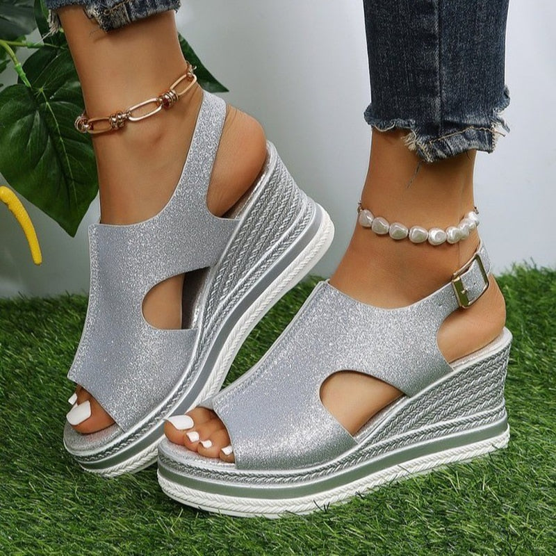 Silberne Keilsandalen mit Plateau, offenem Zehenbereich und Schnallenverschluss. Perfekt für Sommermode und elegante Freizeitlooks.