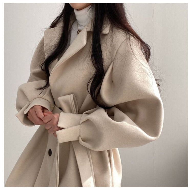 Eleganter beiger Wollmantel für Damen, ideal für Herbst und Winter. Modischer Trenchcoat mit Gürtel, zeitloses Design, hochwertige Materialien.