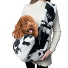 Flauschige Hundetragetasche in Kuhmuster mit kleinem Hund, ideal für Haustiertransport.
