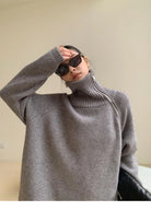 Damenmode: Grauer Rollkragenpullover, oversized, kombiniert mit stilvollen Sonnenbrillen. Trendige Herbstmode, gemütlich und modern.