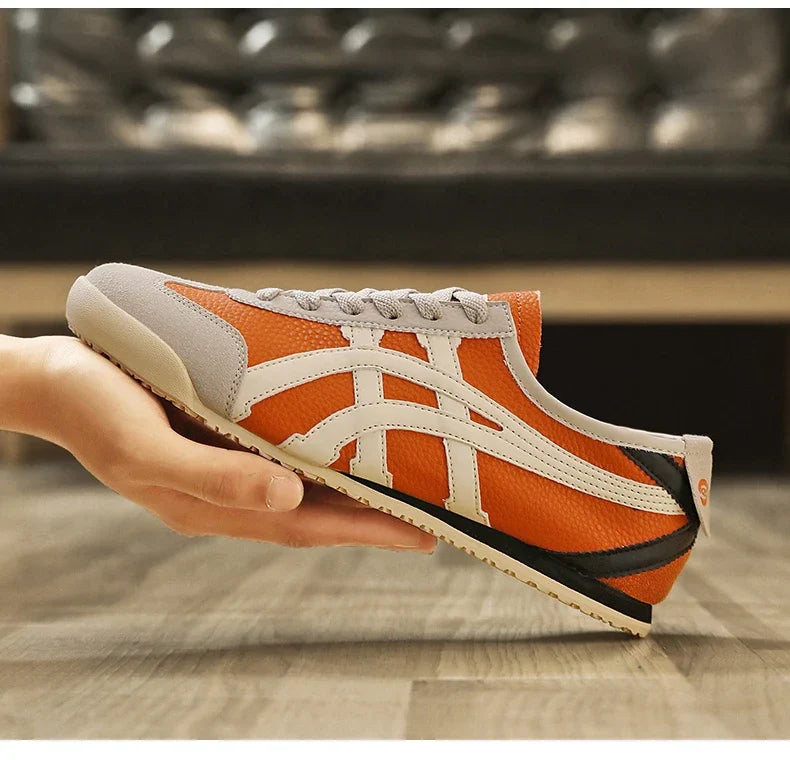 Orangefarbener Sneaker mit weißem Streifenmuster, ideal für Sport und Freizeit. Bequeme Passform, rutschfeste Sohle, trendiges Design.