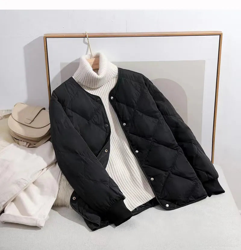 Schwarze Steppjacke mit weißen Knöpfen, kombiniert mit weißem Rollkragenpullover. Perfekt für Herbstmode, stilvoll und warm.