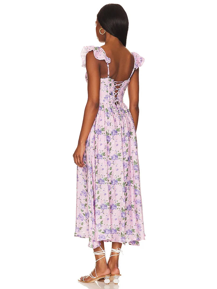 Lila Blumenkleid mit Rüschenärmeln und Schnürung am Rücken, ideal für Sommermode. Perfekt für elegante Anlässe und feminine Outfits.