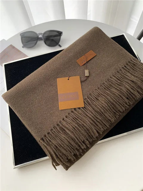 Luxuriöser brauner Kaschmirschal mit Fransen, ideal für stilvolle Wintermode. Hochwertige Accessoires, weiche Textur, zeitloses Design.