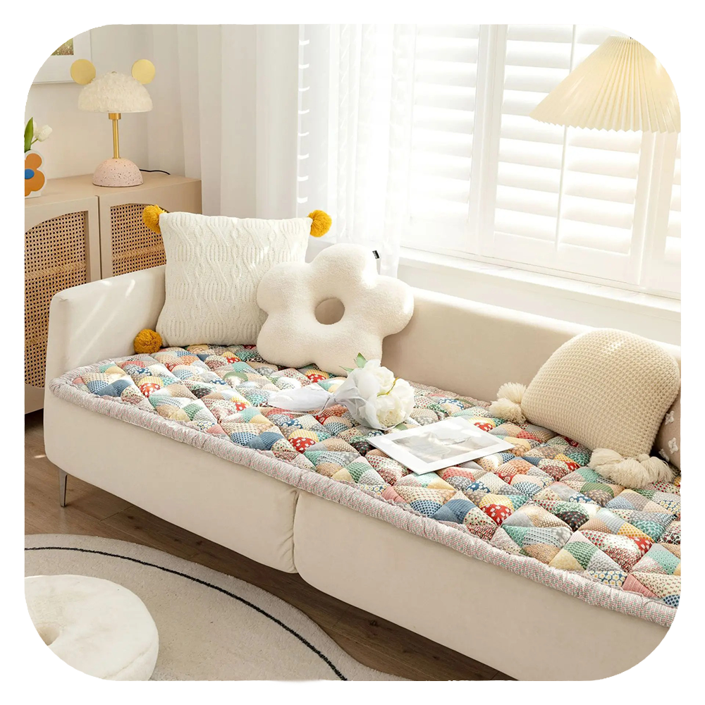 Gemütliches Wohnzimmer mit modernem Sofa, buntem Patchwork-Überwurf und dekorativen Kissen. Perfekte Einrichtungsideen für stilvolle Wohnräume.