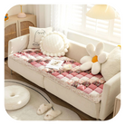 Gemütliches Wohnzimmer mit beigem Sofa, dekoriert mit rosa Patchwork-Decke und Blumen-Kissen. Perfekte Einrichtungsideen für modernes Wohndesign.