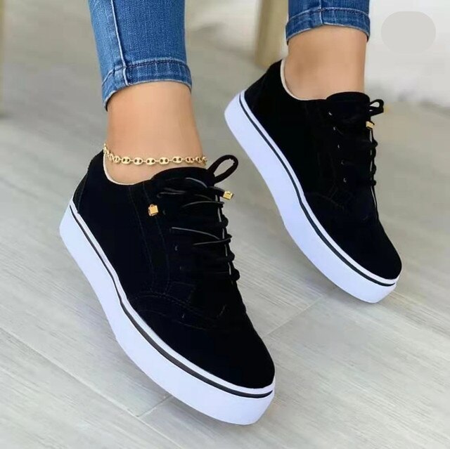 Schwarze Damen-Sneaker mit weißer Sohle, lässig und vielseitig, ideal für Frühling 2023. Modische Turnschuhe, perfekt für Freizeit und Sport.