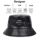 Schwarzer PU-Leder-Bucket-Hut, unisex, mit "N°86 Brooklyn" Label. Modisch, weich, ideal für Outdoor-Aktivitäten. Perfekt für Sonnenschutz.