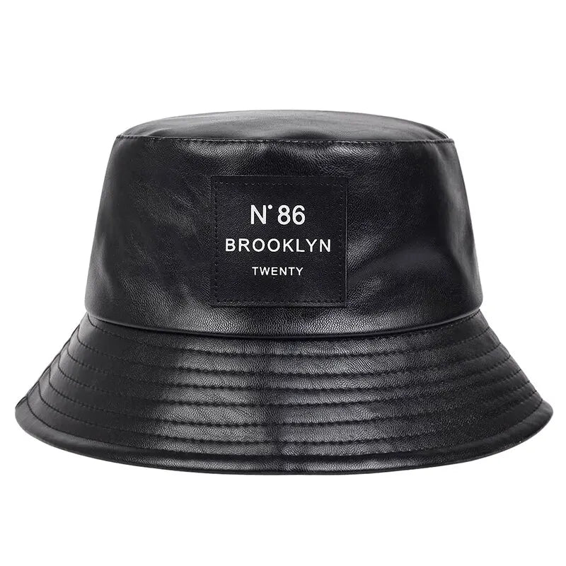 Schwarzer PU-Leder-Bucket-Hut mit "N°86 Brooklyn" Label, ideal für Outdoor-Aktivitäten. Modischer Unisex-Sonnenhut, perfekt für Freizeit und Schutz.