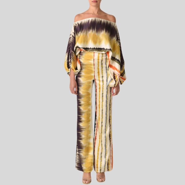 Farbintensiver Damen-Zweiteiler mit Batikmuster, schulterfreiem Oberteil und weiten Hosen. Modetrend, Boho-Stil, auffälliges Design.
