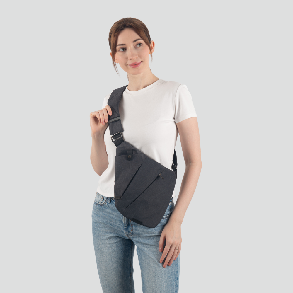 Frau mit schwarzer Umhängetasche, weißem T-Shirt und blauer Jeans, modisches Accessoire.