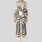Eleganter Jumpsuit mit schwarz-weißem Zebra-Muster, schulterfreiem Design und weitem Bein. Perfekt für modische Anlässe und stilvolle Auftritte.