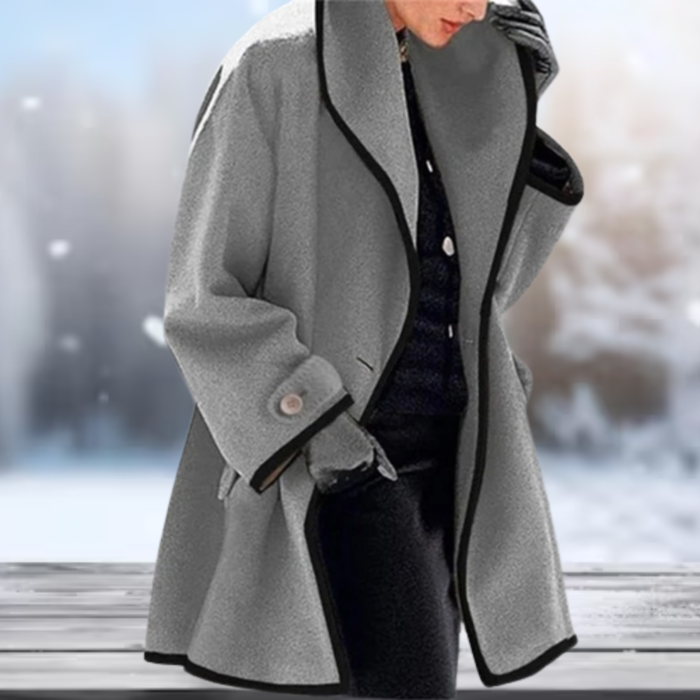 Eleganter grauer Wollmantel für Damen mit schwarzem Rand, ideal für Wintermode. Stilvoller Mantel, warm und modisch für kalte Tage.