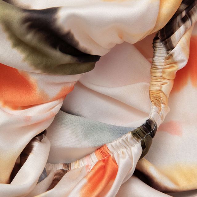 Seidenstoff mit abstraktem Aquarellmuster in Orange, Grün und Schwarz. Hochwertiger Textilstoff, ideal für Mode und Inneneinrichtung.