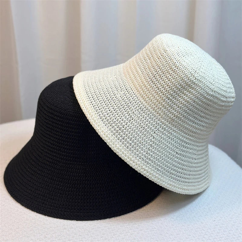 Zwei Retro-Eimerhüte aus Stroh, schwarz und weiß, ideal für Frühling und Sommer. Perfekt als modischer Sonnenschutz und Reiseaccessoire.